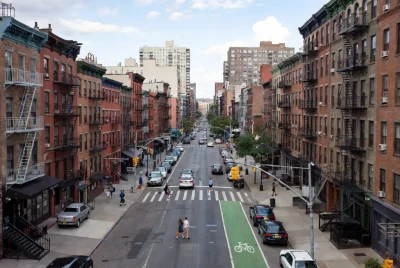 Overhead view of Brooklyn street intersection showing double-parked cars bike lane and crosswalk